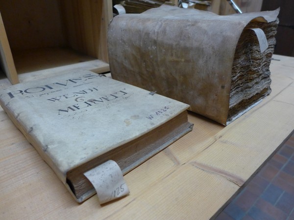 Ein altes Buch und ein Stapel Akten aus dem Archiv des Schlosses Lembeck.